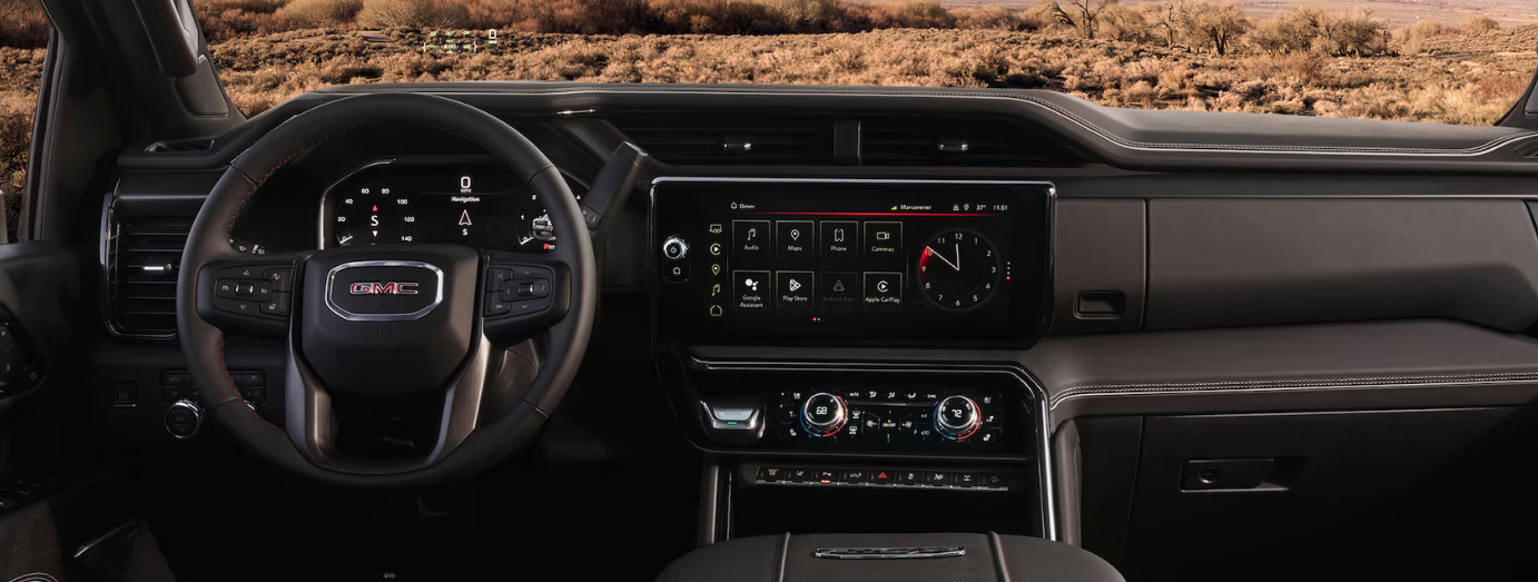 2026 GMC Sierra 2500 HD AT4 navigating off-road terrain showing suspension lift and skid plates