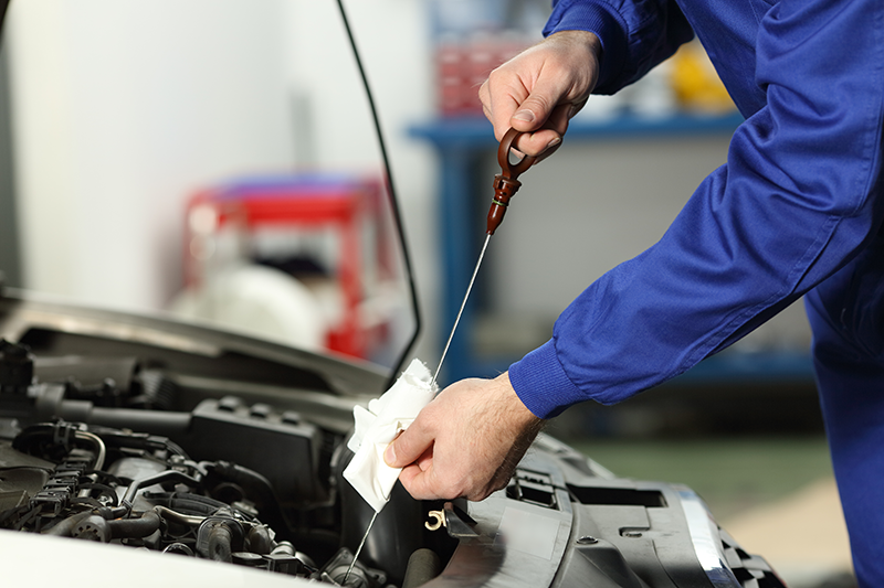Close-up of fresh engine oil being poured during a service appointment